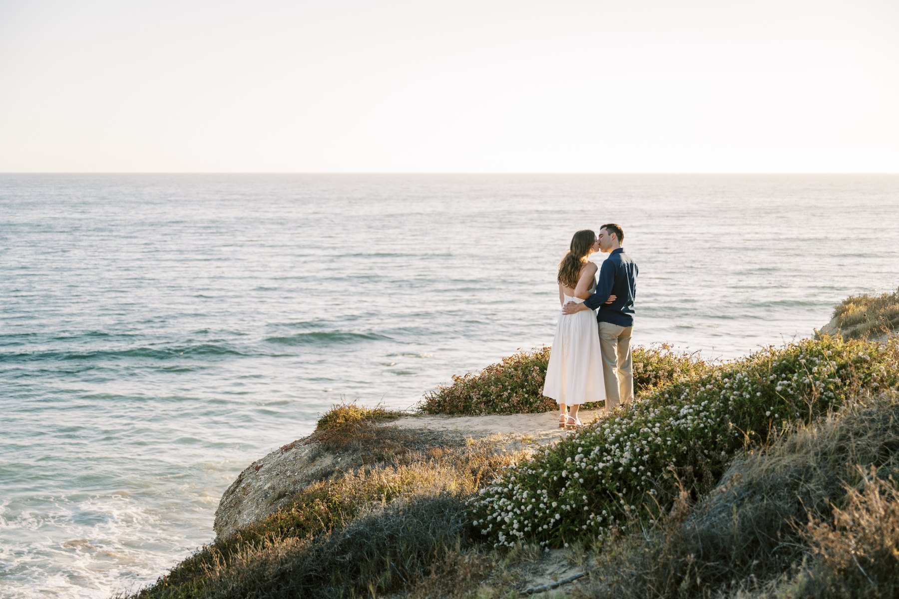 Molly and Nick walking together beside the ocean