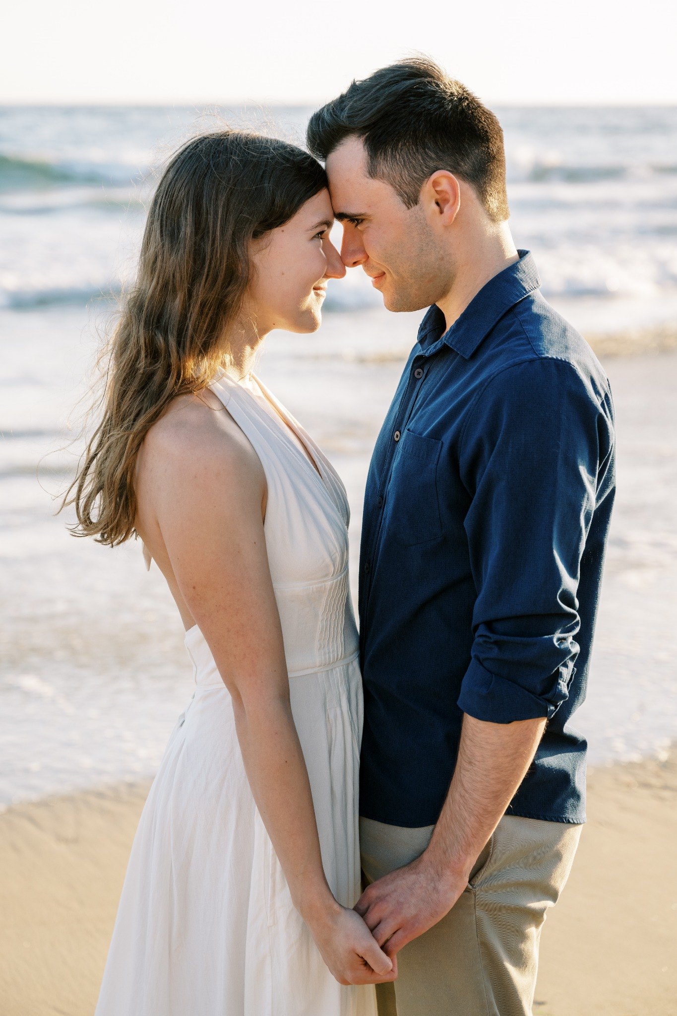 Molly and Nick standing close together at the beach